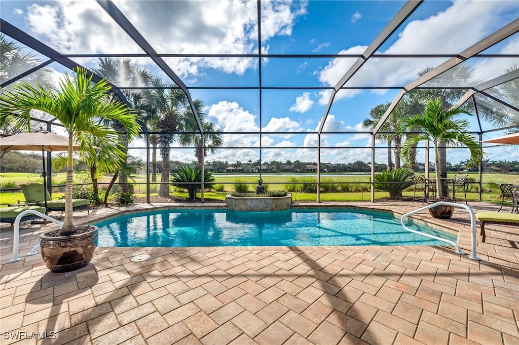 view of pool with a patio and glass enclosure