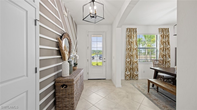 foyer with light tile patterned flooring and a notable chandelier