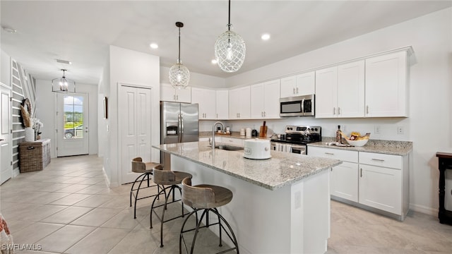 kitchen featuring sink, appliances with stainless steel finishes, white cabinetry, and an island with sink