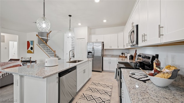 kitchen with a center island with sink, sink, appliances with stainless steel finishes, and white cabinets