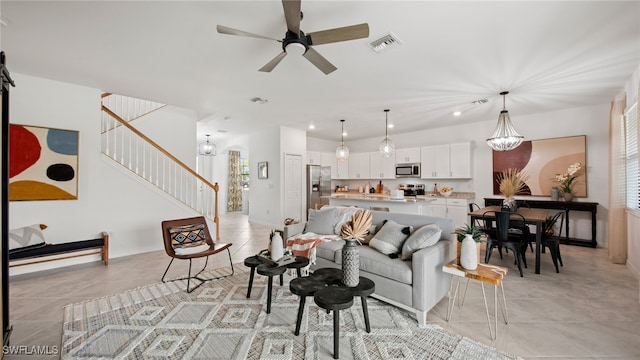 living room with a healthy amount of sunlight, ceiling fan with notable chandelier, and light tile patterned floors