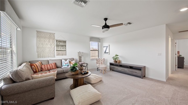 carpeted living room with ceiling fan