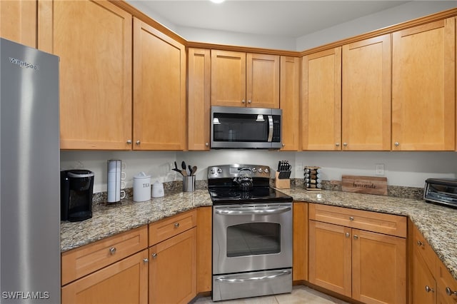 kitchen with light stone countertops and appliances with stainless steel finishes