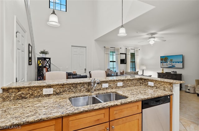 kitchen featuring sink, light stone counters, dishwasher, and a wealth of natural light