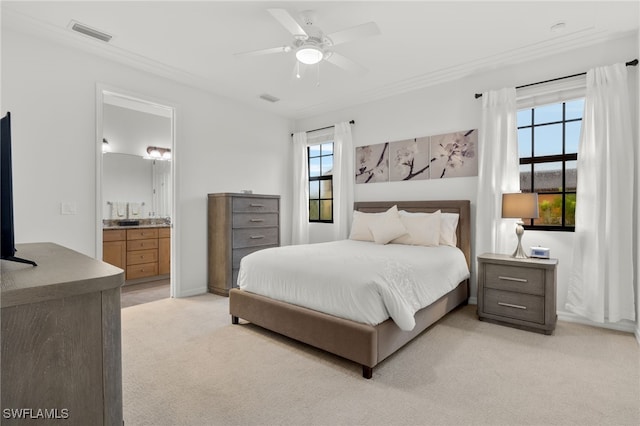 bedroom with connected bathroom, light colored carpet, and ceiling fan