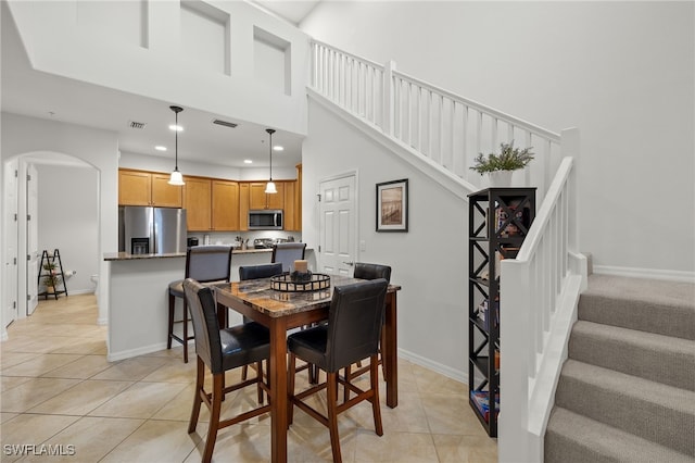 dining room featuring a high ceiling and light tile patterned floors