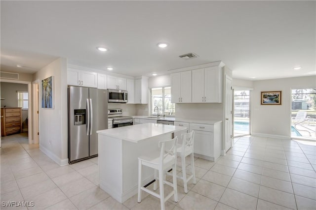 1106 Lorraine Ct, Cape Coral, FL 33904 - kitchen featuring appliances with stainless steel finishes, light tile patterned flooring, light countertops, white cabinetry, and recessed lighting