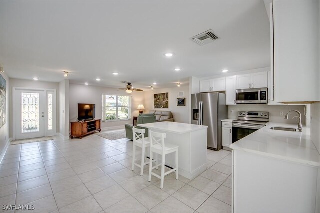 1106 Lorraine Ct, Cape Coral, FL 33904 - kitchen featuring stainless steel appliances, open floor plan, a center island, light countertops, and light tile patterned floors