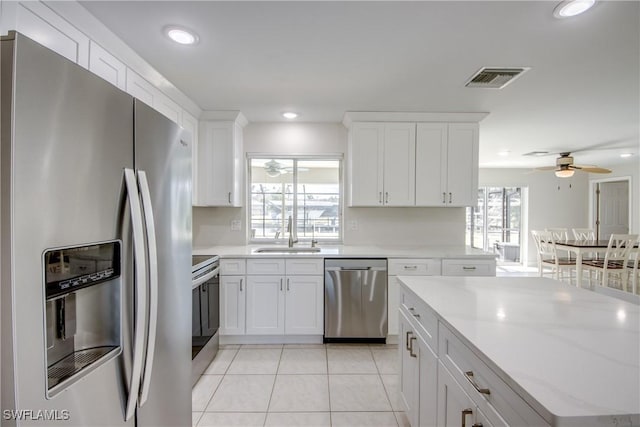 1106 Lorraine Ct, Cape Coral, FL 33904 - kitchen with stainless steel appliances, ceiling fan, light tile patterned floors, white cabinets, and recessed lighting