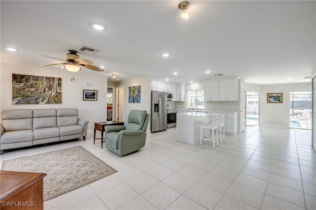 1106 Lorraine Ct, Cape Coral, FL 33904 - living area with light tile patterned flooring, recessed lighting, a ceiling fan, and healthy amount of natural light