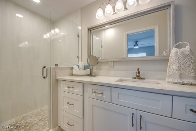 bathroom with a shower with door, vanity, and ceiling fan