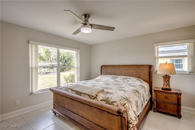 tiled bedroom with ceiling fan and multiple windows