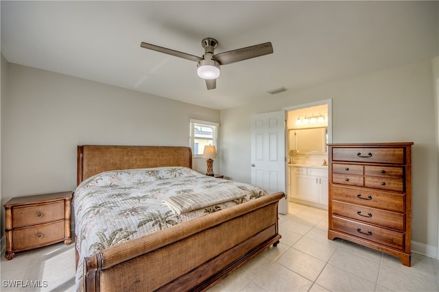 bedroom with ensuite bath, light tile patterned floors, and ceiling fan