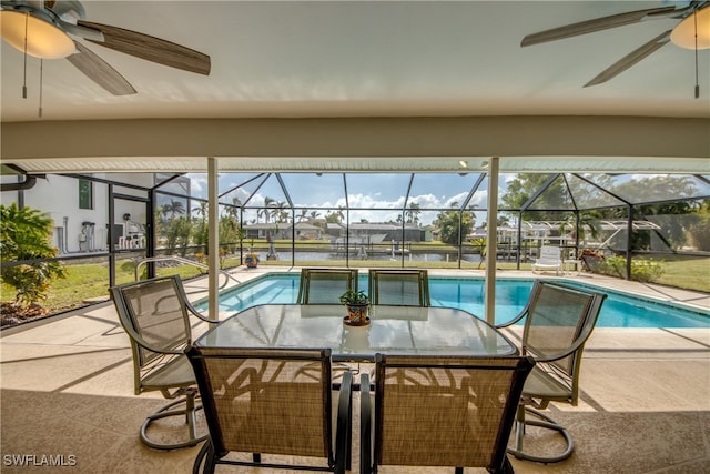 view of swimming pool with a patio area, glass enclosure, and ceiling fan