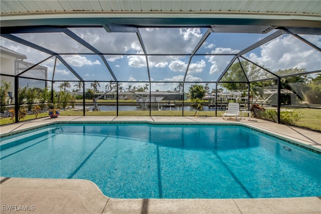 view of pool featuring a patio, a water view, and glass enclosure