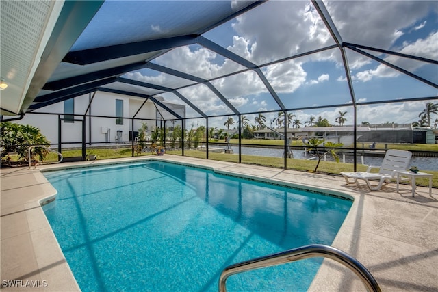 view of swimming pool with a water view, a patio area, glass enclosure, and a lawn