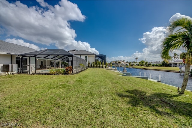 view of yard featuring a swimming pool, a water view, and a lanai