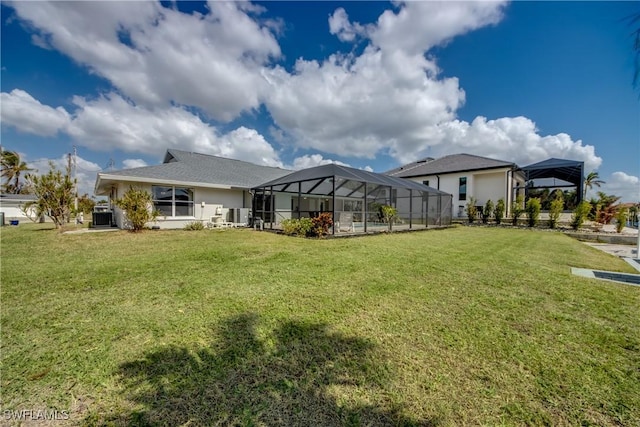 1106 Lorraine Ct, Cape Coral, FL 33904 - rear view of house with a yard, glass enclosure, and stucco siding