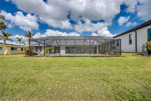 rear view of house with a yard and glass enclosure