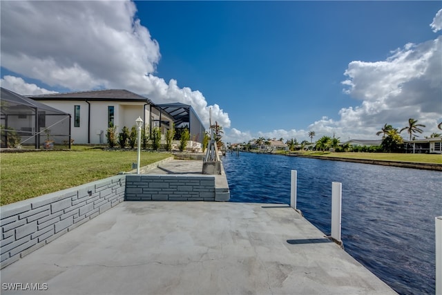 view of dock with a yard, a water view, and glass enclosure