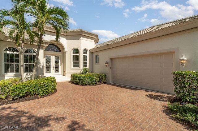 mediterranean / spanish-style house featuring french doors and a garage