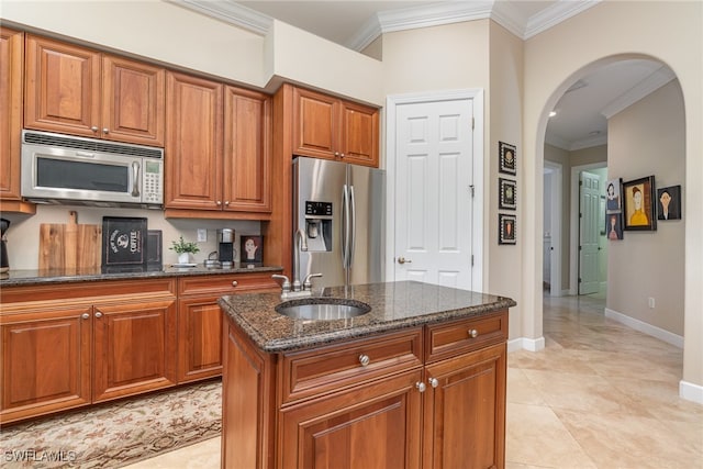 kitchen with sink, a center island, dark stone countertops, appliances with stainless steel finishes, and ornamental molding