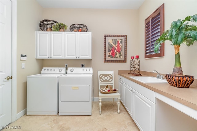 washroom with cabinets, sink, and washer and dryer