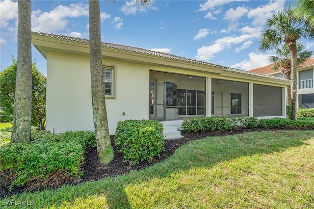 back of property featuring a sunroom and a yard