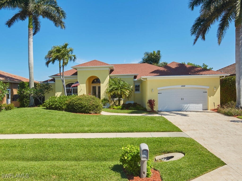 mediterranean / spanish home with a front yard and a garage