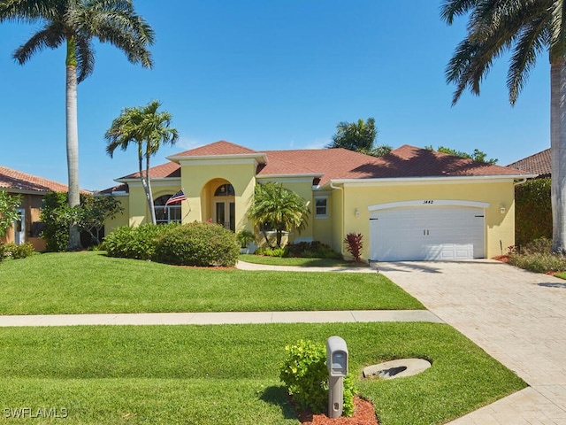 1442 Biscayne Way, Marco Island, FL 34145 - mediterranean / spanish-style house with an attached garage, driveway, a front yard, and stucco siding