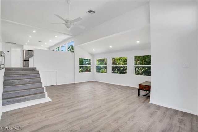 unfurnished living room with light wood-style flooring, visible vents, stairway, and baseboards