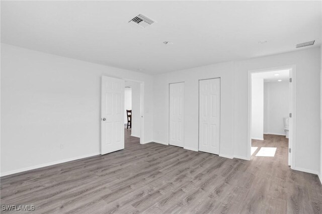 interior space featuring light wood-style floors, visible vents, and baseboards