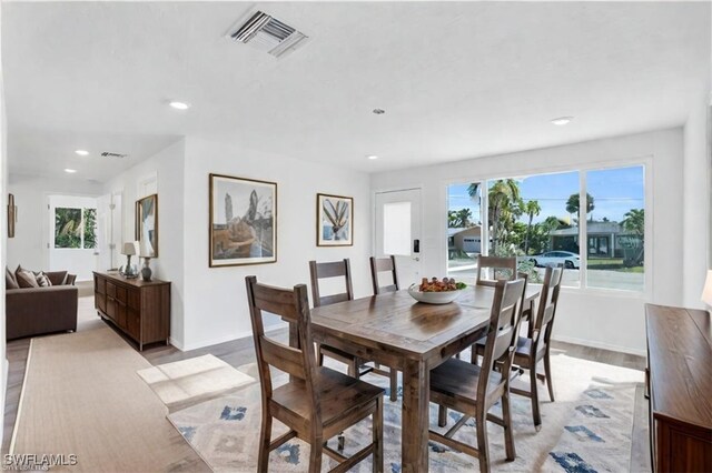 dining room featuring light wood finished floors, recessed lighting, visible vents, and baseboards