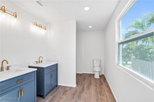 full bathroom featuring two vanities, a sink, visible vents, and baseboards