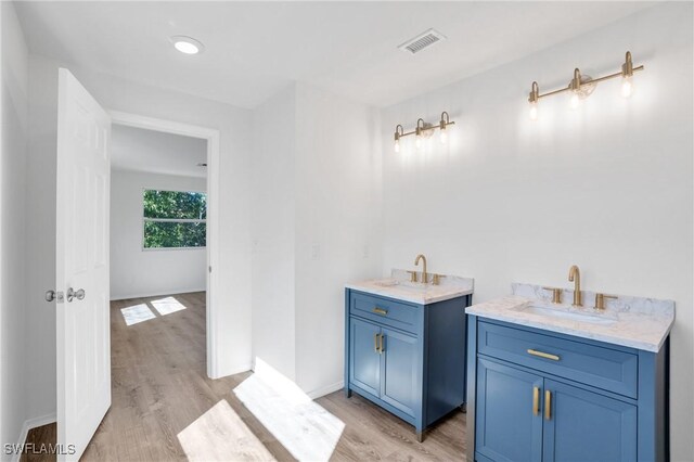 bathroom with visible vents, a sink, and wood finished floors