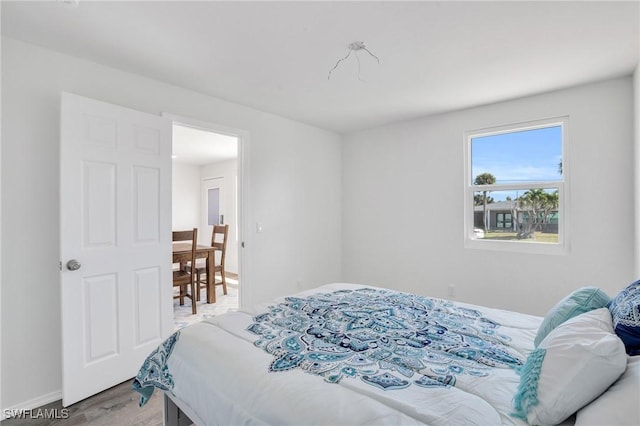 bedroom featuring light wood-style flooring and baseboards