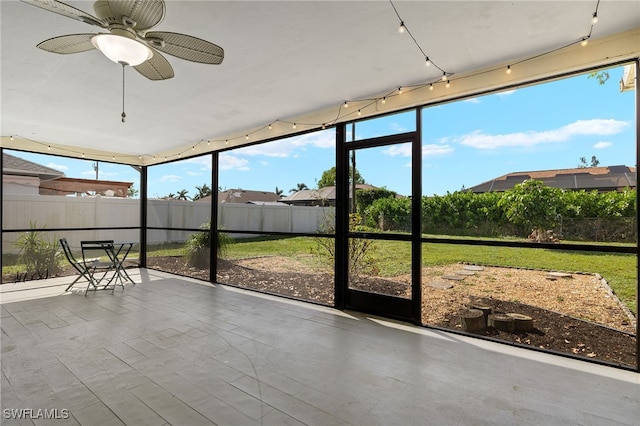 unfurnished sunroom with ceiling fan