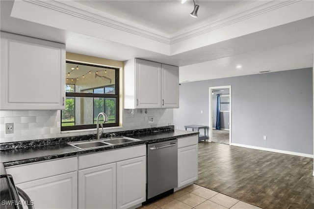 kitchen with sink, ornamental molding, stainless steel dishwasher, white cabinets, and light wood-type flooring