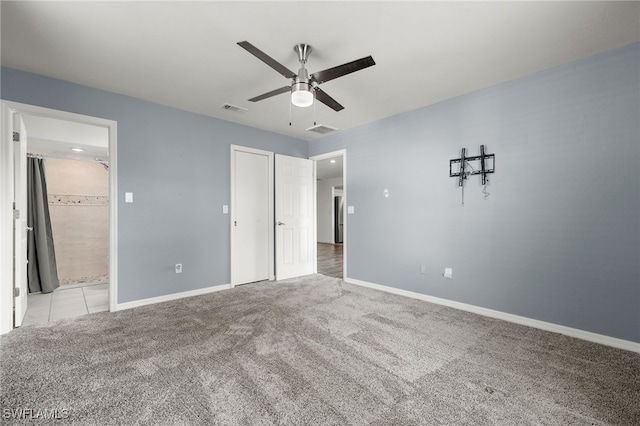 unfurnished bedroom with ensuite bath, light carpet, ceiling fan, and a closet