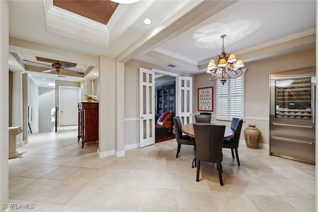 tiled dining room with ceiling fan with notable chandelier, ornamental molding, french doors, and a tray ceiling