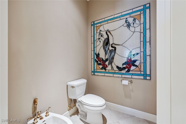 bathroom featuring toilet, a bidet, and tile patterned floors