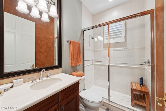 bathroom featuring vanity, toilet, and a shower with door