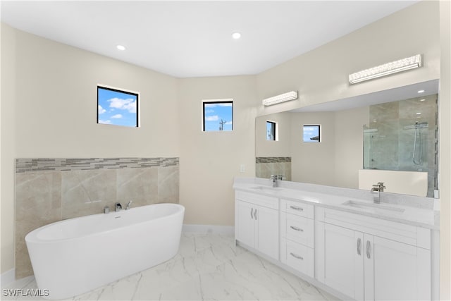 bathroom with plus walk in shower, vanity, and tile walls