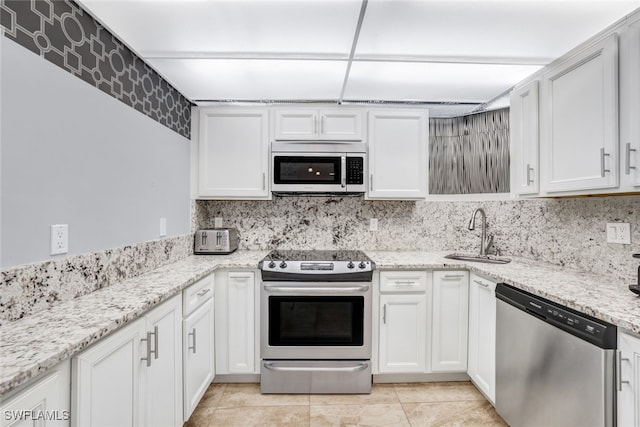 kitchen featuring light stone countertops, sink, white cabinets, and stainless steel appliances