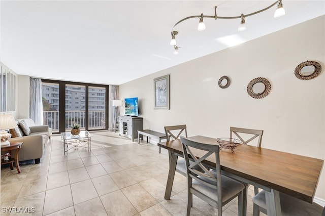 dining room featuring track lighting, light tile patterned flooring, and floor to ceiling windows