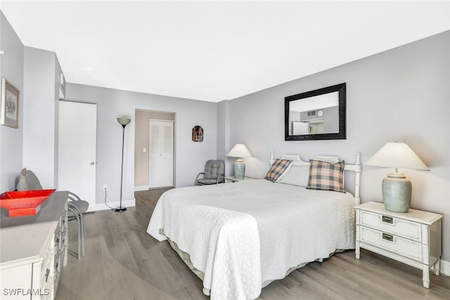 bedroom with baseboards and wood finished floors