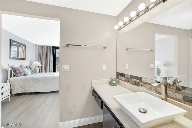 ensuite bathroom with vanity, ensuite bathroom, baseboards, and wood finished floors