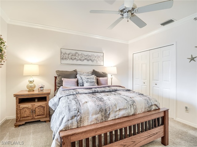 bedroom featuring light carpet, a closet, ceiling fan, and crown molding