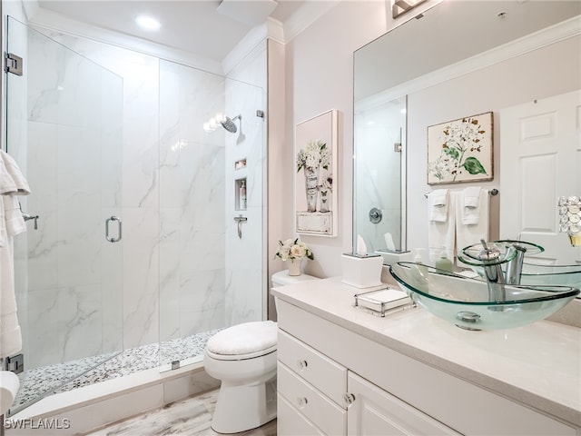 bathroom with toilet, vanity, an enclosed shower, and ornamental molding