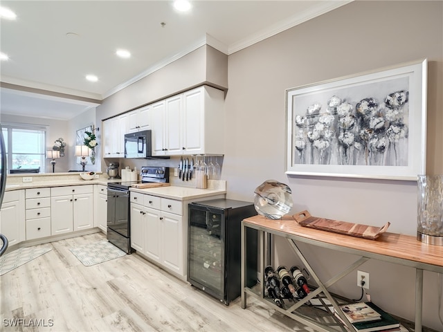 kitchen featuring beverage cooler, crown molding, black appliances, white cabinets, and light hardwood / wood-style floors